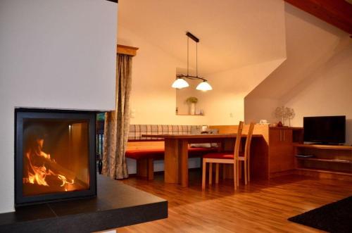 a living room with a fireplace in front of a table at Modernes Appartement vor herrlicher Gebirgskulisse mit zwei Balkonen und Kamin in Umhausen