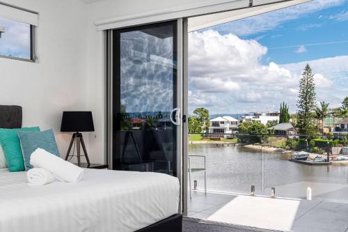 a bedroom with a bed and a view of a river at A Perfect Stay - Ray of Sunshine in Gold Coast