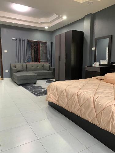 a bedroom with a bed and a living room at Fullmoon Jomtien Guest house in Jomtien Beach