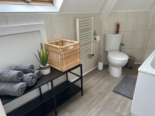 a bathroom with a toilet and a table with towels at Wembley Stadium Serviced Apartments, 12mins to Central London in London
