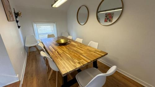 a dining room with a wooden table and white chairs at Harbert's Gem in Harbert