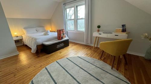 a bedroom with a bed and a chair and a window at Harbert's Gem in Harbert
