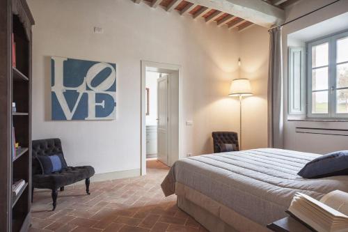 um quarto com uma cama, uma cadeira e um candeeiro em Ferienwohnung für 4 Personen ca 120 qm in Montaione, Toskana Provinz Florenz - b60298 em Castelfalfi
