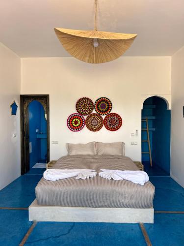 a bedroom with a large bed in a room with blue floors at Aghmat Lodge Guest house in Marrakech