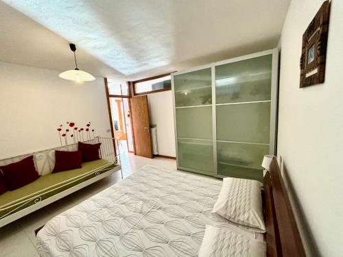 a bedroom with a bed and a couch in it at Appartamento SOLE in Brenzone sul Garda