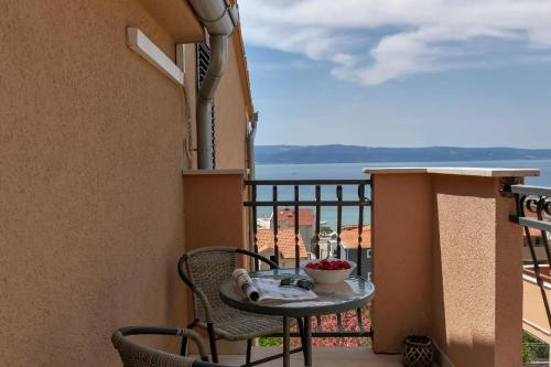 einen Tisch auf einem Balkon mit Meerblick in der Unterkunft Gästezimmer für zwei Personen mit Balkon in Duće