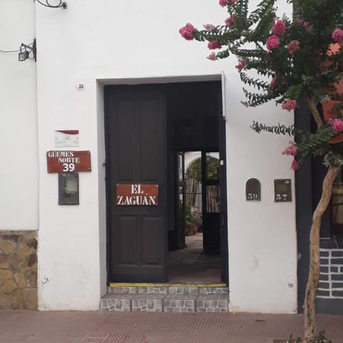 una entrada a un edificio con una puerta negra en EL ZAGUAN ANEXO I en Cafayate