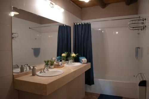 a bathroom with two sinks and a tub and a mirror at Besares 722 in Chacras de Coria