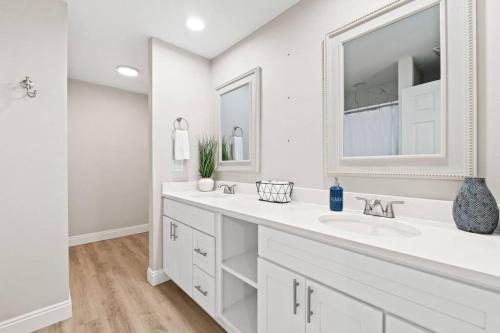 a white bathroom with a sink and a mirror at The Heather Marie - Stylish and Modern Rambler in Panama City