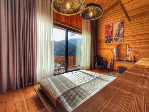 sypialnia z łóżkiem i dużym oknem w obiekcie Filin Resort w mieście Iczewan