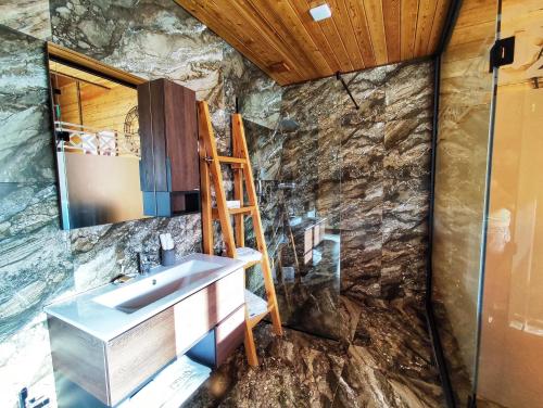 un bagno con un muro in pietra con un lavandino e una scala di Filin Resort a Ijevan