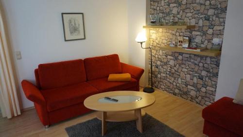 salon z czerwoną kanapą i stołem w obiekcie Appartement in Äußere Neustadt mit Terrasse w Dreźnie