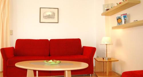 uma sala de estar com um sofá vermelho e uma mesa em Appartement in Äußere Neustadt mit Terrasse em Dresden