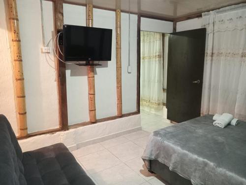 ein Wohnzimmer mit einem Flachbild-TV und einem Sofa in der Unterkunft APARTA ESTUDIO DONDE ANITA in Salento