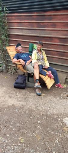 two men sitting on a bench with their arms crossed at coraizone hostel in Cobán