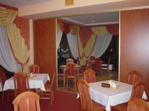 comedor con 2 mesas, sillas y cortinas en Pokoje Gościnne Arkadia, en Łabowa