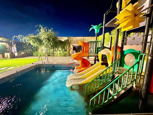 a swimming pool with a slide in a house at شاليه ضفاف - Difaf Chalet - فخم وجديد وفاخر in Jeddah