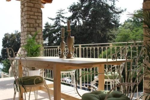 une table en bois avec deux bougies sur une terrasse dans l'établissement Charmantes Ferienhaus in Toscolano Maderno mit Botanischem Garten und Seeblick, à Toscolano Maderno