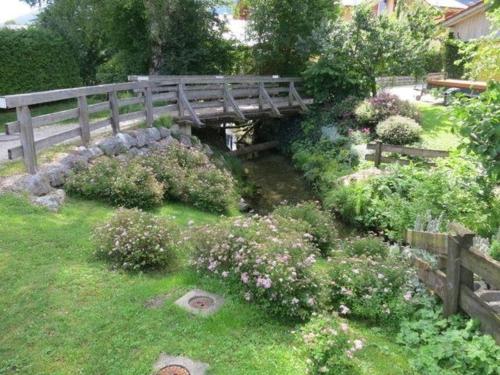 a wooden bridge over a garden with flowers at Ferienwohnung für 4 Personen ca 55 qm in Inzell, Bayern Oberbayern in Inzell