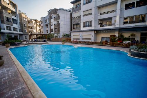 a large blue swimming pool in front of some buildings at Mirage residence resort in Cairo