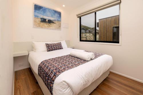 a bedroom with a bed and a window at BIG4 Apollo Bay Pisces Holiday Park in Apollo Bay