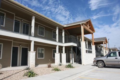 a building with a car parked in front of it at Eagle's Den Suites Big Spring a Travelodge by Wyndham in Big Spring