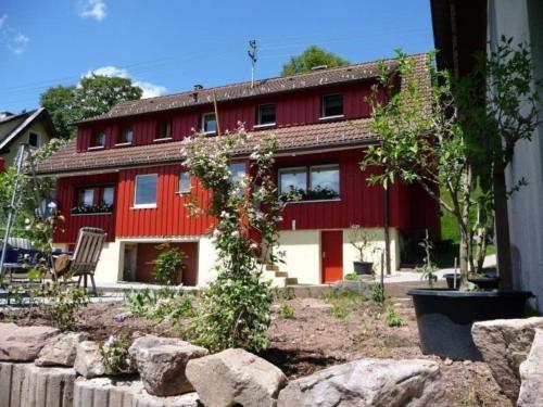 Oberbränd的住宿－Ferienhaus für 3 Personen 1 Kind ca 85 qm in Eisenbach, Schwarzwald Naturpark Südschwarzwald，前面有一棵树的红色房子