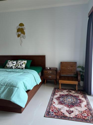 1 dormitorio con 1 cama, 1 silla y 1 alfombra en Bratavilla, en Ketewel