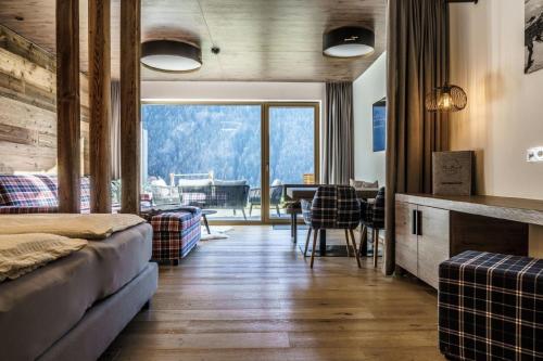 a bedroom with a couch and a table with a view at Ferienwohnungen direkt an der Skiabfahrt und MTB-Trails - b56870 in Sölden