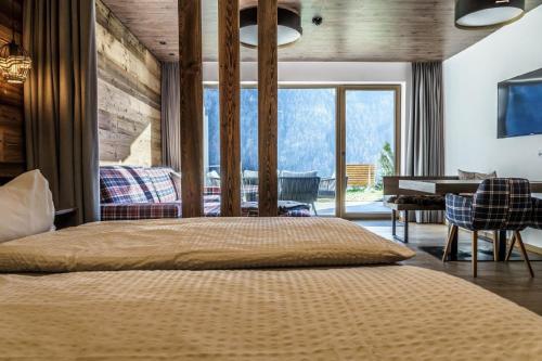 1 dormitorio con 1 cama grande en una habitación con escritorio en Ferienwohnungen direkt an der Skiabfahrt und MTB-Trails - b56870 en Sölden