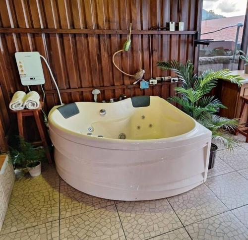 bañera grande en una sala con plantas en Love House Arenal-Volcano & Lake views, en Fortuna