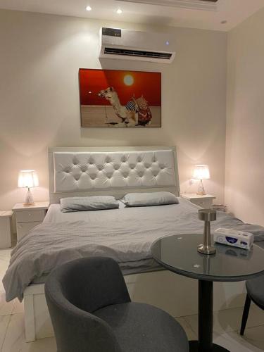 a bedroom with a bed with a table and two chairs at Dareen Boutique in Abha