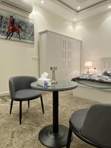 um quarto com uma mesa e duas cadeiras e uma cama em Dareen Boutique em Abha