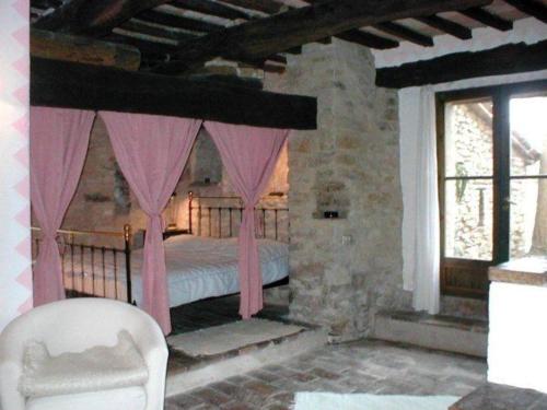 1 dormitorio con cama con dosel y cortinas rosas en Ferienhaus für 4 Personen 1 Kind ca 80 qm in Piandimeleto, Marken Provinz Pesaro-Urbino en Piandimeleto