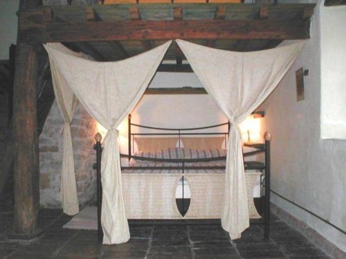 1 dormitorio con cama con dosel y cortinas en Ferienhaus für 4 Personen 1 Kind ca 80 qm in Piandimeleto, Marken Provinz Pesaro-Urbino en Piandimeleto