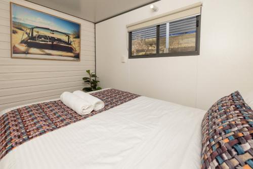 a bedroom with a white bed and two windows at BIG4 Apollo Bay Pisces Holiday Park in Apollo Bay