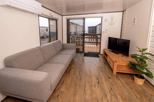 a living room with a couch and a flat screen tv at BIG4 Apollo Bay Pisces Holiday Park in Apollo Bay