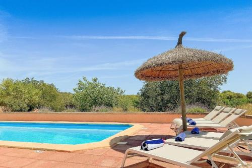 a pair of chairs and an umbrella next to a swimming pool at Ferienhaus mit Privatpool für 6 Personen ca 120 qm in Campos, Mallorca Südküste von Mallorca in Campos