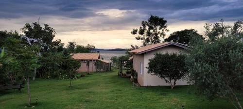 a yard with two small buildings and a body of water at Casinha na Represa 1 in CÃ¡ssia