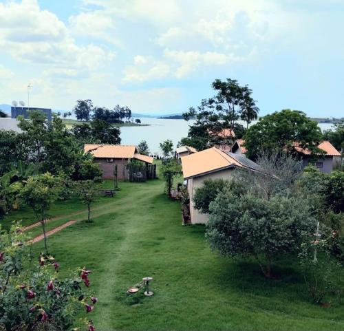 a yard with houses and a lake in the background at Casinha na Represa 1 in CÃ¡ssia