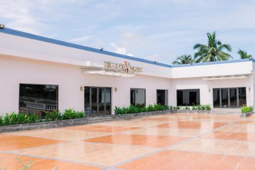 a large white building with a tiled courtyard at NGOC THU HOTEL in Soc Trang