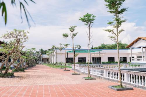 a row of trees in front of a building at NGOC THU HOTEL in Soc Trang