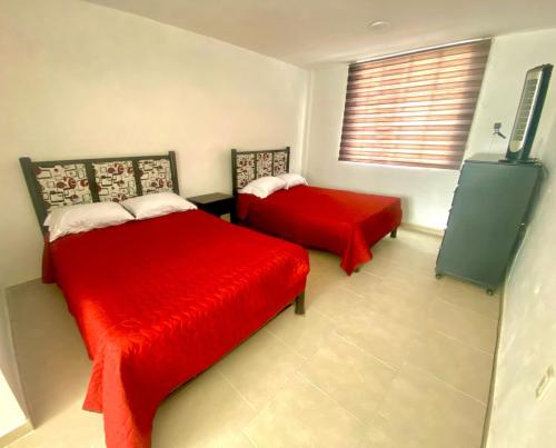 Casa de descanso con piscina Galileos في ليون: غرفة نوم بسريرين ذات أغطية حمراء ونافذة