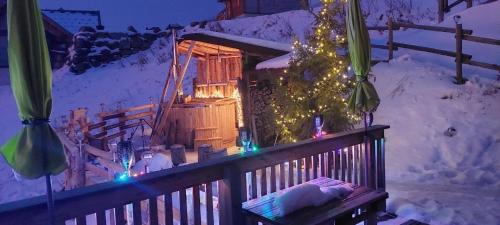 a balcony with a christmas tree and a house with lights at Die Berghexn, am Klippitztörl in Bad Sankt Leonhard im Lavanttal