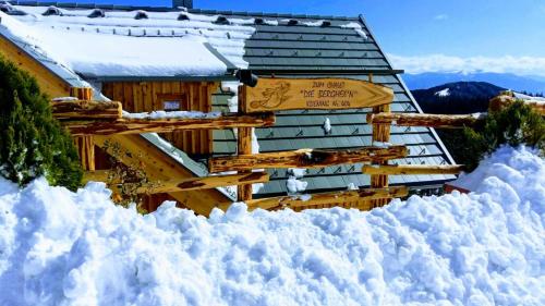 a sign in the snow in front of a cabin at Die Berghexn, am Klippitztörl in Bad Sankt Leonhard im Lavanttal