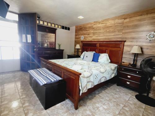ein Schlafzimmer mit einem Bett und einer Bank darin in der Unterkunft Cozy Corner w/private pool in Vega Baja