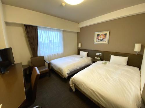 En eller flere senge i et værelse på Hotel Route-Inn Hanamaki