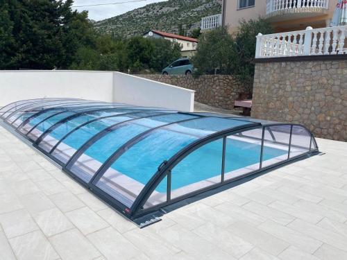 a swimming pool with a glass roof on a patio at Große Ferienwohnung in Starigrad mit Möbliertem Balkon in Starigrad