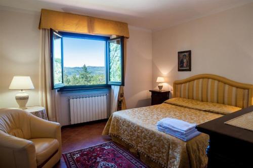 1 dormitorio con cama y ventana grande en Großes Ferienhaus in Lonnano mit Schönem Garten, en Pratovecchio