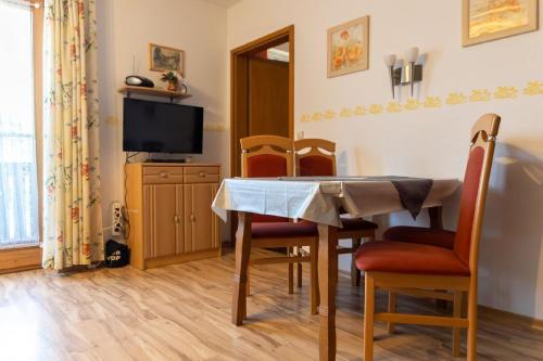 a dining room with a table and chairs and a television at Ferienwohnung mit zwei Schlafzimmern und Balkon in Weißenstadt